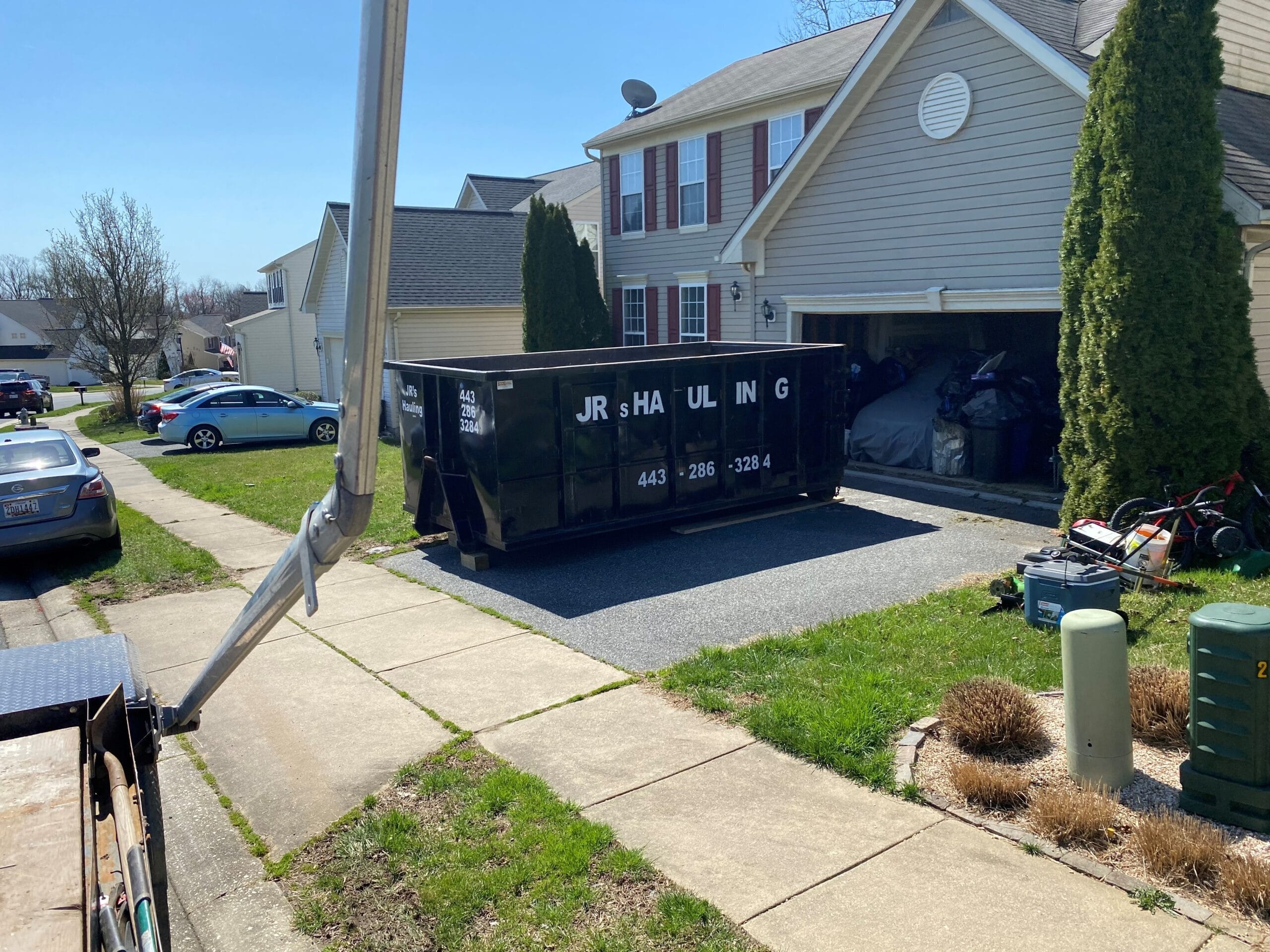 Roll-Off Dumpster Rental - JRS DUMPSTER RENTAL Roll-off dumpster placed on driveway with plywood surface protection
